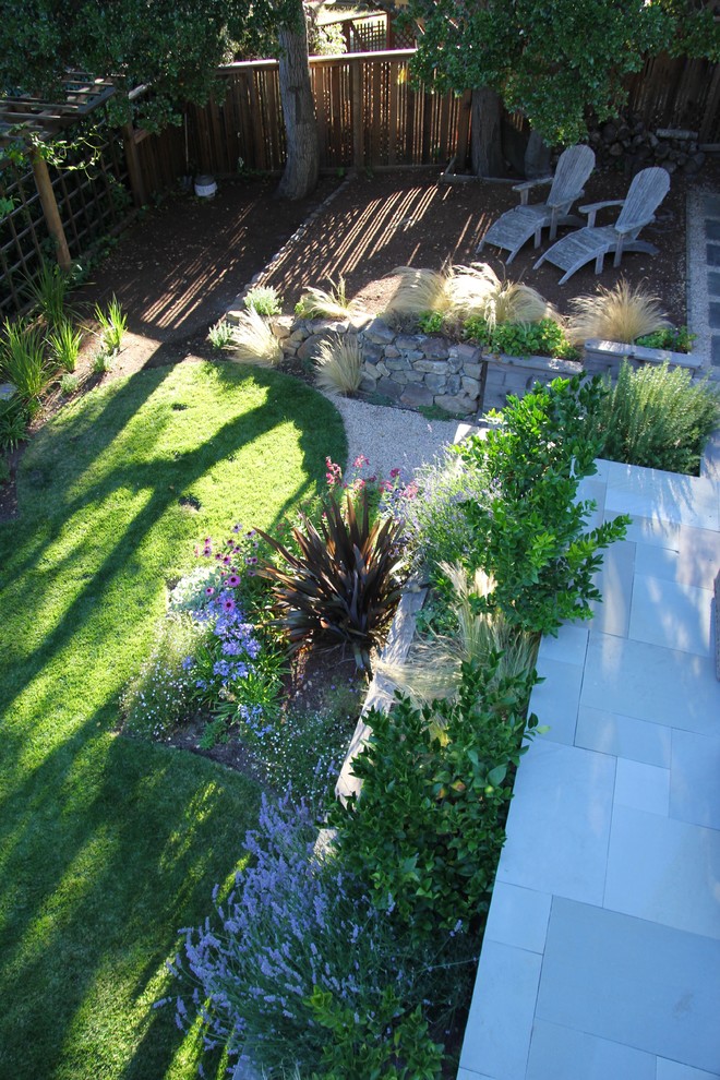 Imagen de jardín de estilo de casa de campo de tamaño medio en patio trasero con muro de contención, exposición reducida al sol y mantillo