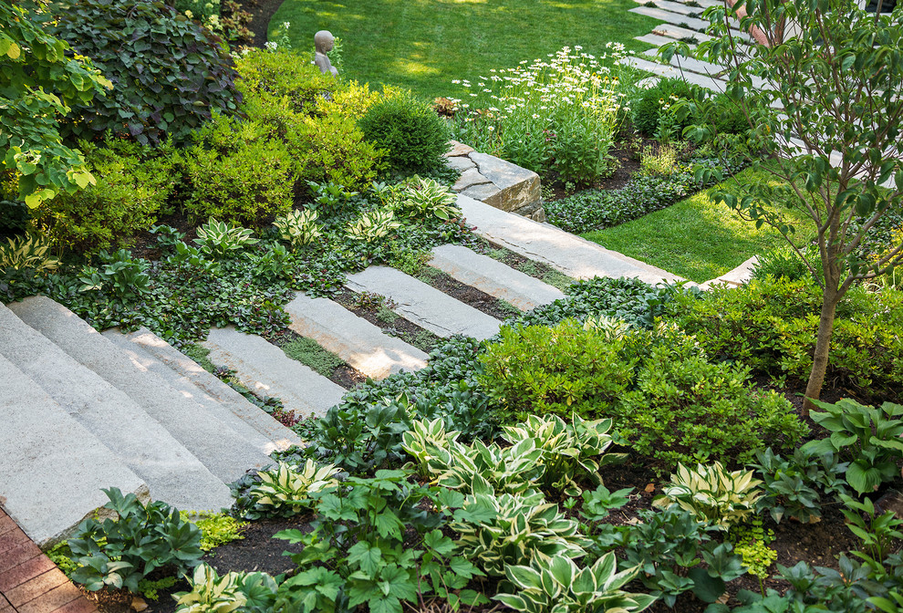 Diseño de jardín clásico de tamaño medio en patio trasero con exposición parcial al sol y adoquines de piedra natural