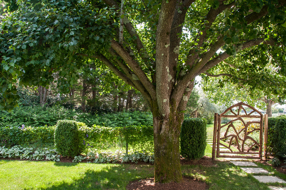 Idée de décoration pour un jardin arrière tradition de taille moyenne avec une exposition partiellement ombragée et des pavés en pierre naturelle.