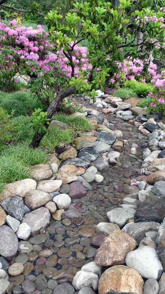 Design ideas for a huge traditional partial sun backyard brick landscaping in New York for summer.