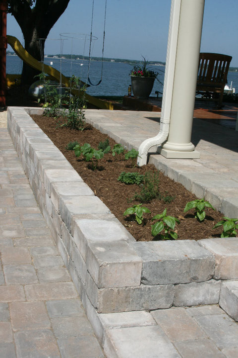 This is an example of a small front driveway full sun garden in Baltimore with concrete paving.