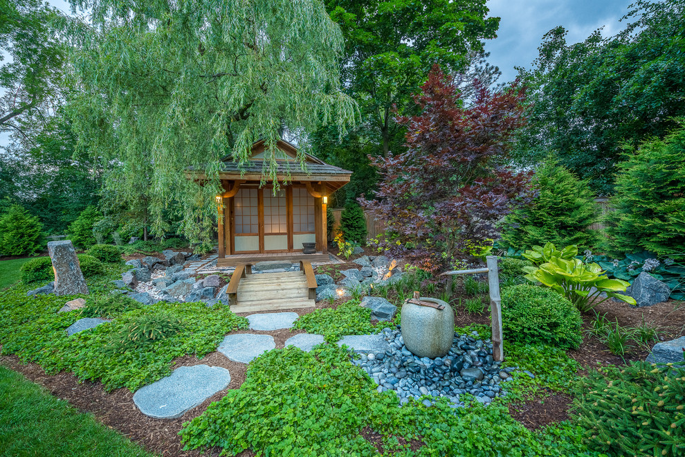Идея дизайна: большой участок и сад на заднем дворе в восточном стиле с полуденной тенью и покрытием из каменной брусчатки