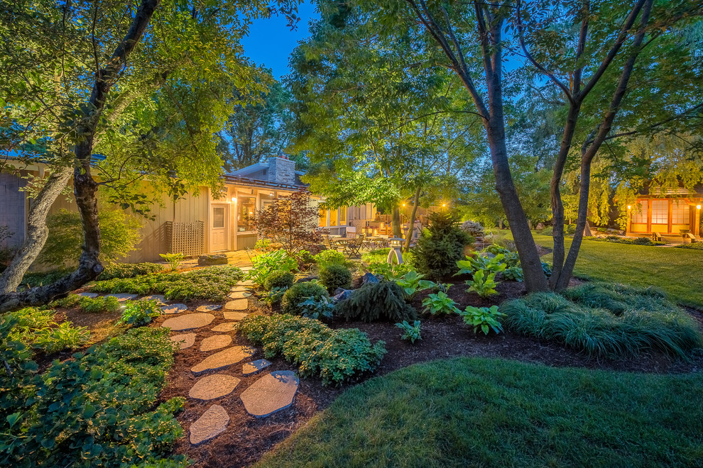 Design ideas for a large asian partial sun backyard stone landscaping in Milwaukee.