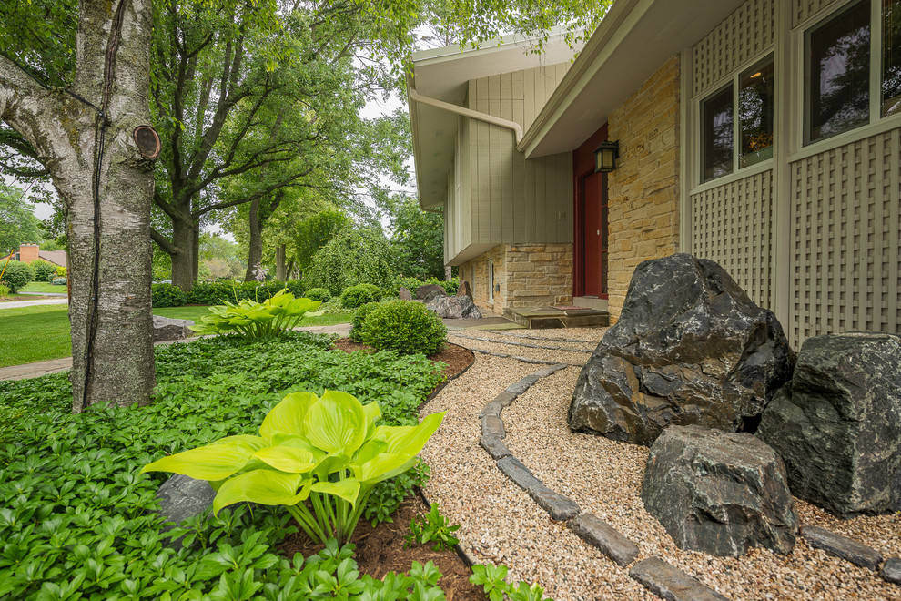 Design ideas for a mid-sized asian partial sun front yard stone landscaping in Milwaukee.