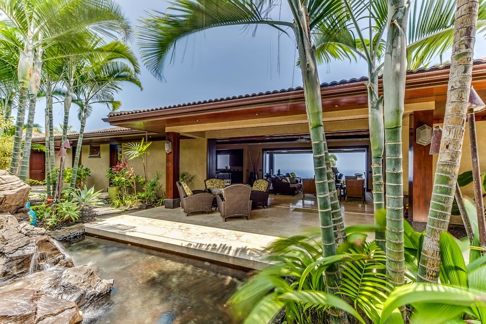 This is an example of a huge tropical full sun side yard stone water fountain landscape in Hawaii for summer.
