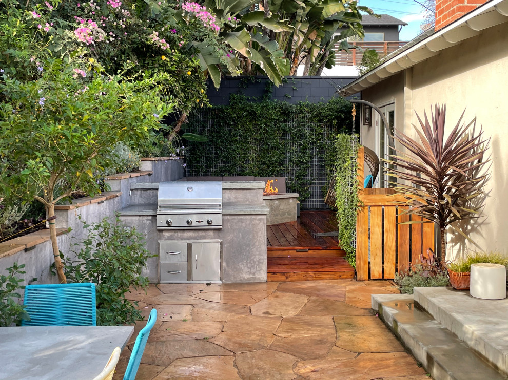 Kleiner Moderner Patio hinter dem Haus mit Feuerstelle und Natursteinplatten in Los Angeles