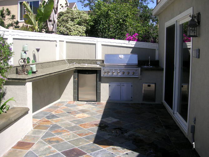 Photo of a large contemporary back full sun garden in Orange County with natural stone paving.