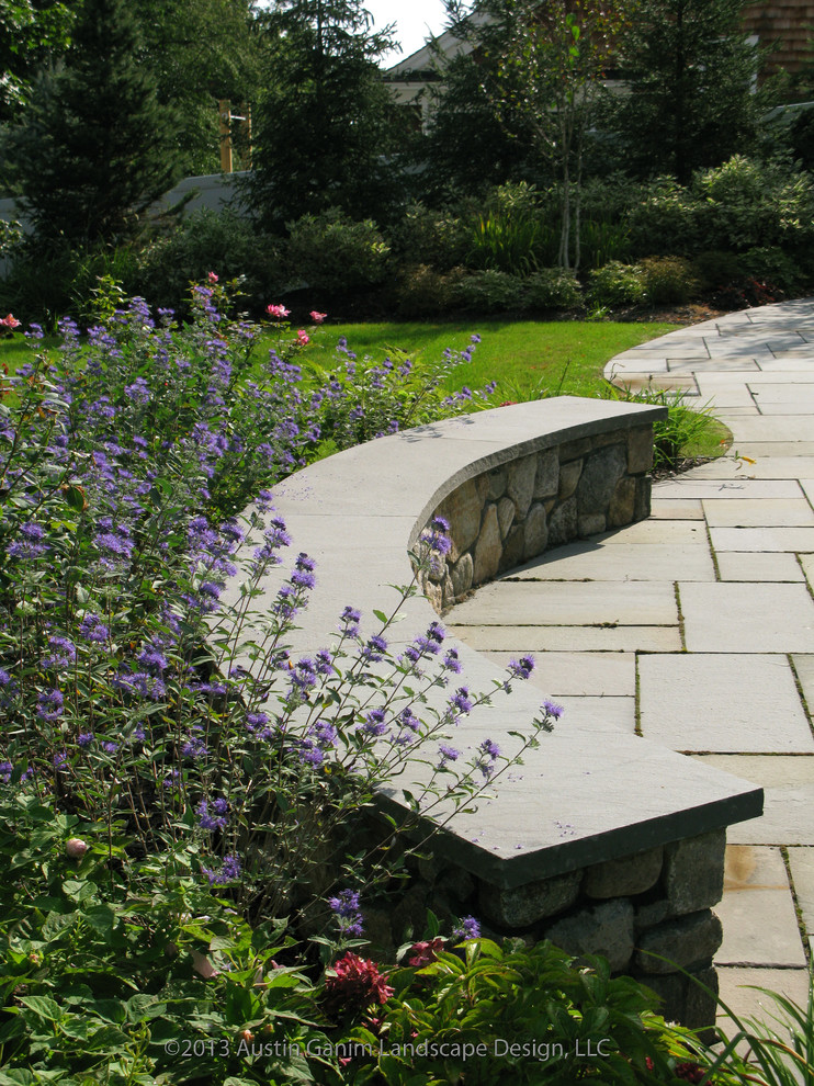 Idee per un giardino design esposto in pieno sole dietro casa in autunno con un muro di contenimento e pavimentazioni in pietra naturale