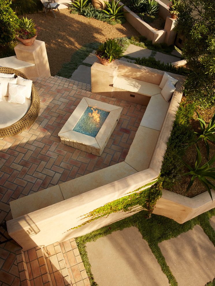 Idee per un giardino xeriscape mediterraneo esposto a mezz'ombra di medie dimensioni e davanti casa con un focolare e pavimentazioni in cemento