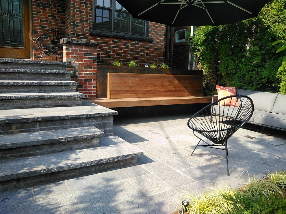 Пример оригинального дизайна: солнечный участок и сад среднего размера на переднем дворе в стиле модернизм с подпорной стенкой, хорошей освещенностью и покрытием из каменной брусчатки