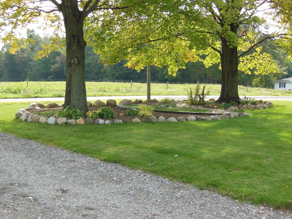 Cette image montre un petit jardin avant traditionnel l'été avec une exposition ensoleillée et un paillis.