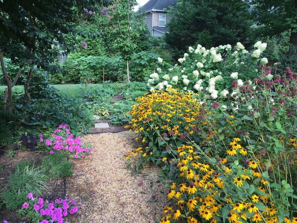 Inspiration pour un grand jardin arrière traditionnel au printemps avec une exposition partiellement ombragée et des pavés en pierre naturelle.
