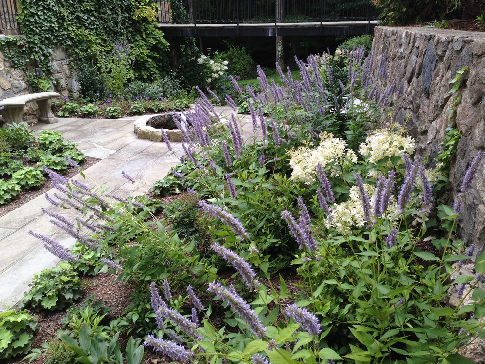 Diseño de jardín clásico de tamaño medio en patio con muro de contención y adoquines de piedra natural