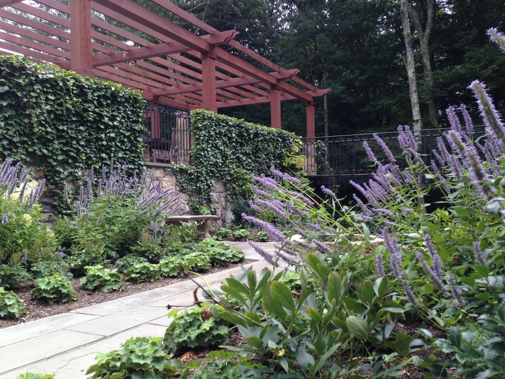 Пример оригинального дизайна: участок и сад среднего размера на внутреннем дворе в классическом стиле с подпорной стенкой и покрытием из каменной брусчатки