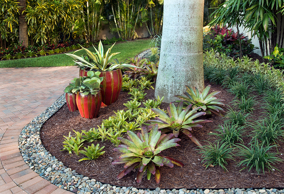 Foto di un grande giardino tropicale esposto a mezz'ombra davanti casa con un giardino in vaso e pavimentazioni in mattoni