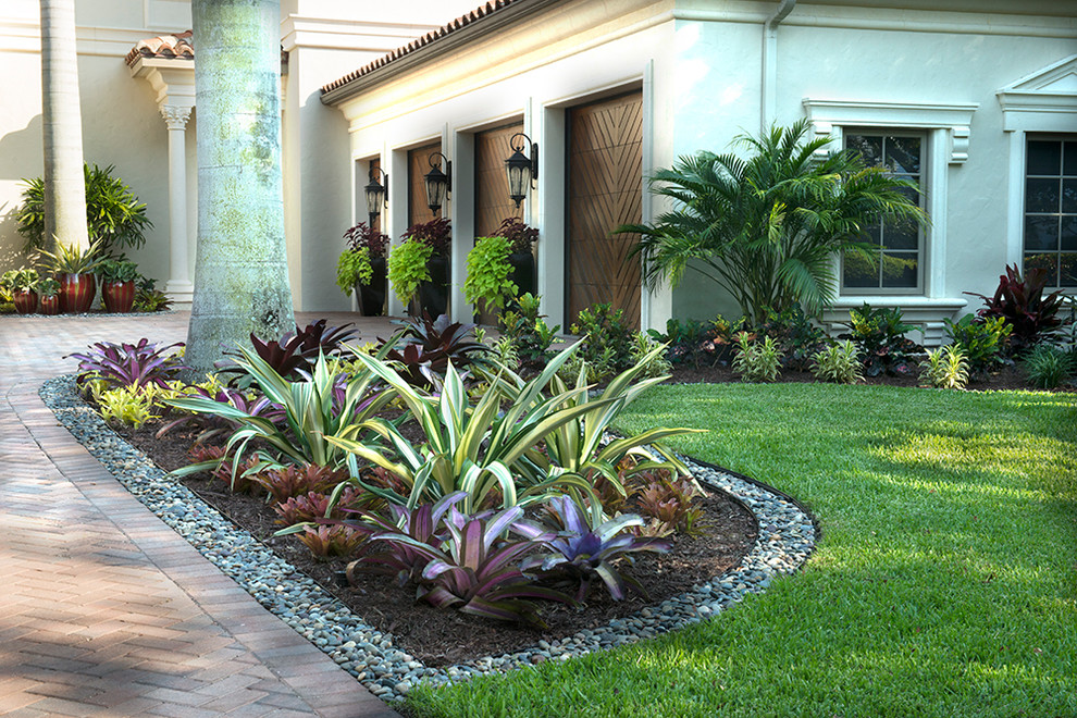 Foto di un giardino tropicale esposto a mezz'ombra di medie dimensioni e davanti casa con pavimentazioni in mattoni