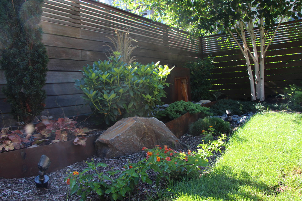 Стильный дизайн: маленький регулярный сад зимой на переднем дворе в восточном стиле с подпорной стенкой, полуденной тенью и покрытием из каменной брусчатки для на участке и в саду - последний тренд