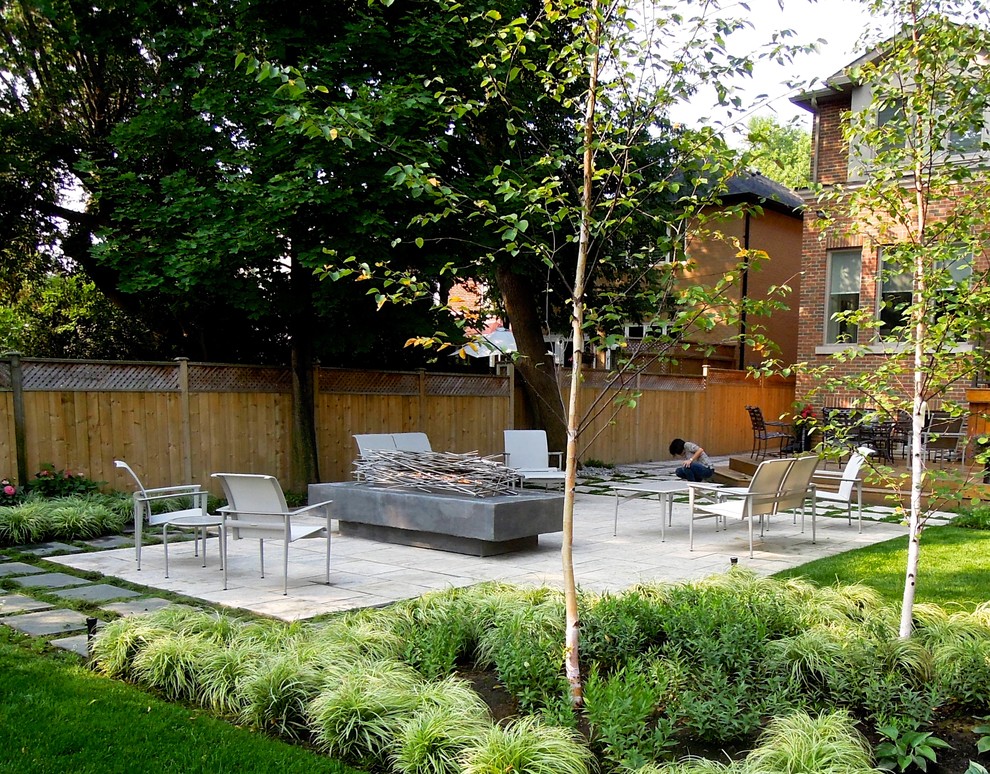 Cette image montre un jardin arrière design avec un foyer extérieur, une exposition partiellement ombragée et des pavés en pierre naturelle.