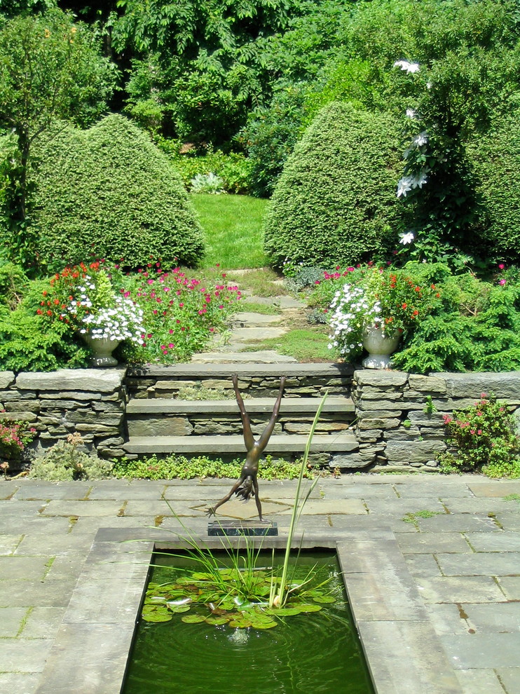 Design ideas for a mid-sized traditional courtyard water fountain landscape in Burlington.