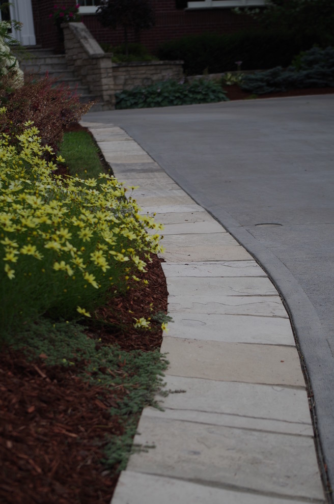 Inspiration for a large traditional front yard stone driveway in Toronto.
