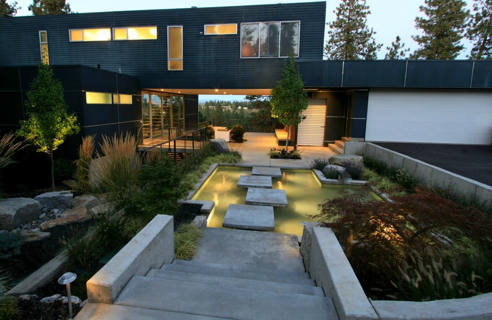 Идея дизайна: сад с прудом на переднем дворе в стиле модернизм с подъездной дорогой и покрытием из каменной брусчатки