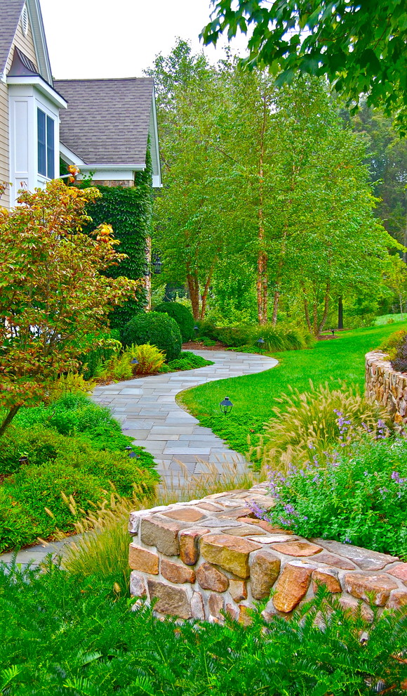 Photo of a large traditional side yard stone landscaping in New York.