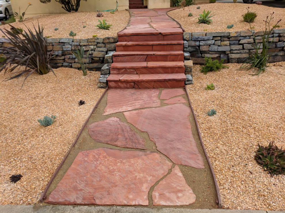 Aménagement d'un petit xéropaysage avant sud-ouest américain avec un mur de soutènement et des pavés en pierre naturelle.