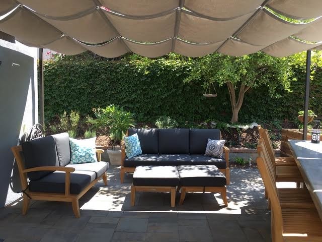 Diseño de jardín clásico grande en patio trasero con exposición reducida al sol y adoquines de hormigón