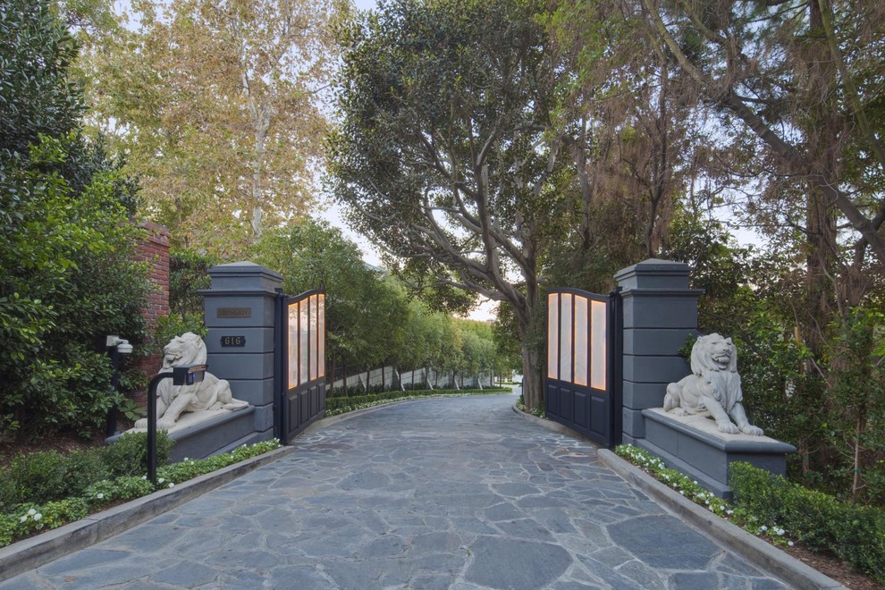 This is an example of a huge traditional shade front yard stone driveway in Los Angeles.