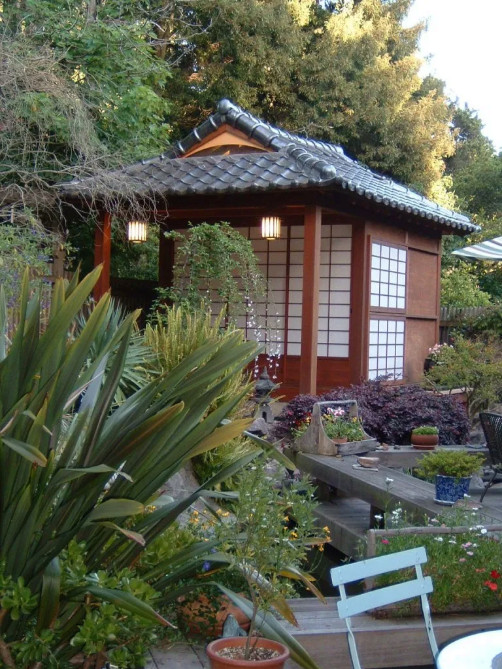Imagen de jardín asiático en patio trasero con jardín francés, exposición parcial al sol y adoquines de piedra natural