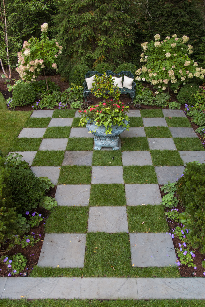 Foto de jardín tradicional de tamaño medio en patio trasero con jardín francés, exposición parcial al sol y adoquines de piedra natural