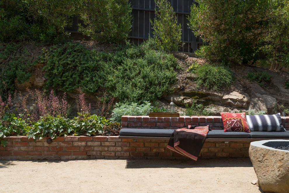 Modelo de jardín de secano minimalista pequeño en primavera en patio trasero con muro de contención y exposición parcial al sol