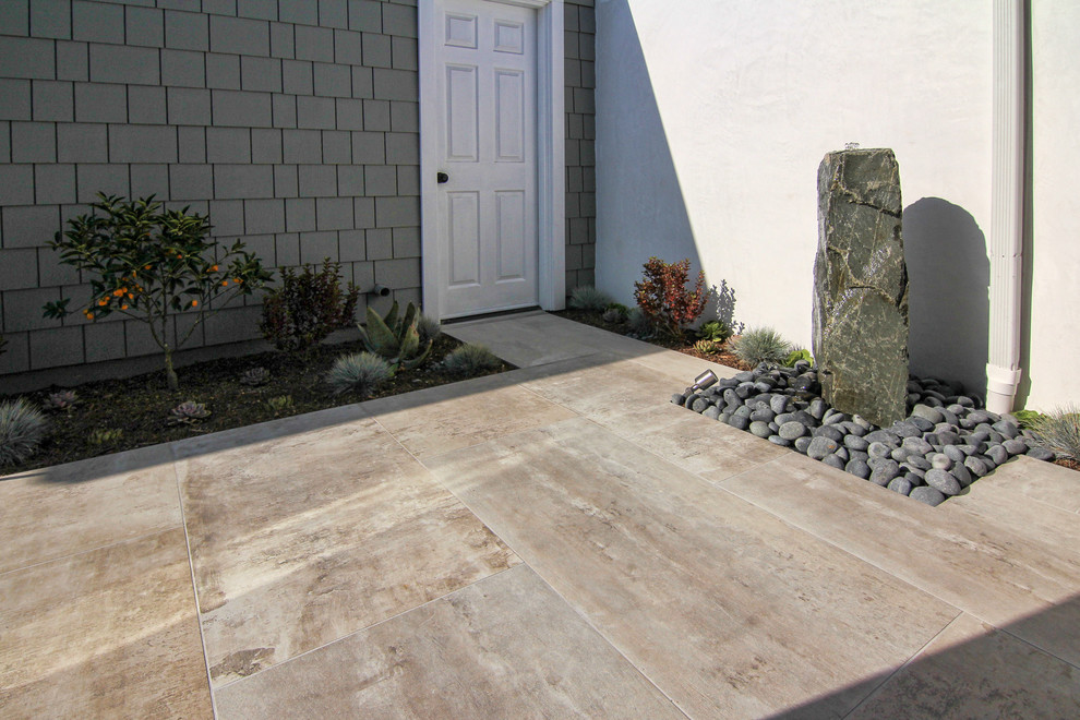 Medium sized modern back partial sun garden for spring in Orange County with a garden path and concrete paving.