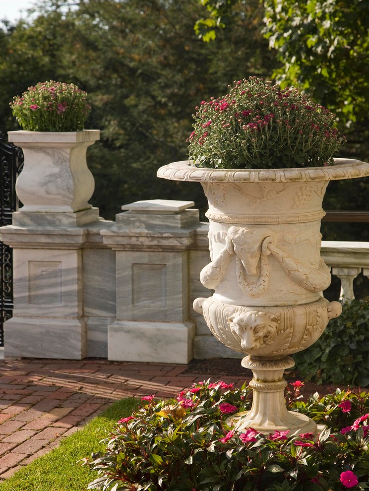 Foto de jardín clásico grande en ladera con adoquines de ladrillo
