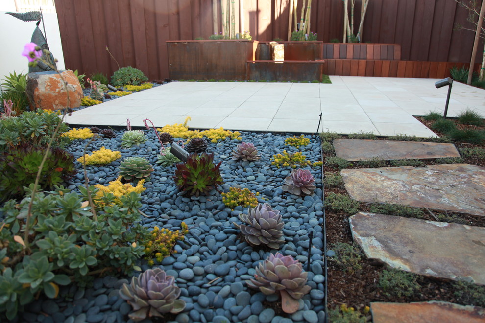 Design ideas for a mid-sized modern drought-tolerant and partial sun backyard concrete paver landscaping in San Francisco.