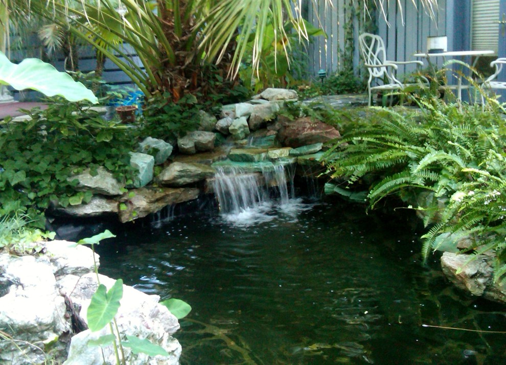 Ispirazione per un giardino tropicale esposto a mezz'ombra in cortile con fontane e pavimentazioni in pietra naturale