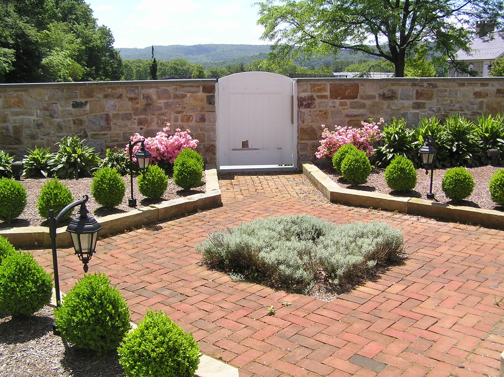 Ispirazione per un giardino formale tradizionale esposto a mezz'ombra di medie dimensioni e in cortile in primavera con un ingresso o sentiero e pavimentazioni in mattoni