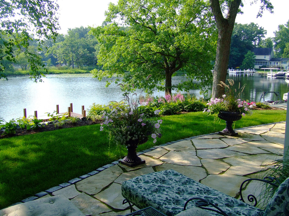 Inspiration for a mid-sized traditional backyard stone landscaping in Milwaukee.