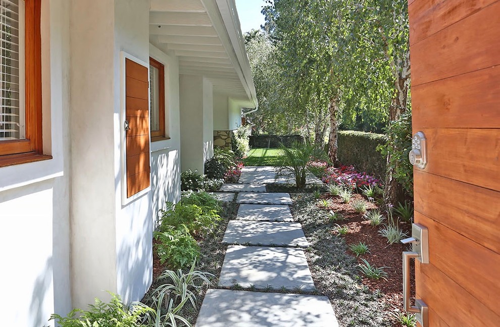 Medium sized retro side xeriscape fully shaded garden in Los Angeles with a garden path and concrete paving.