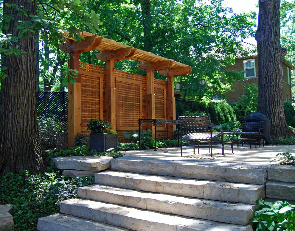 This is an example of a large craftsman shade backyard stone landscaping in Chicago for summer.