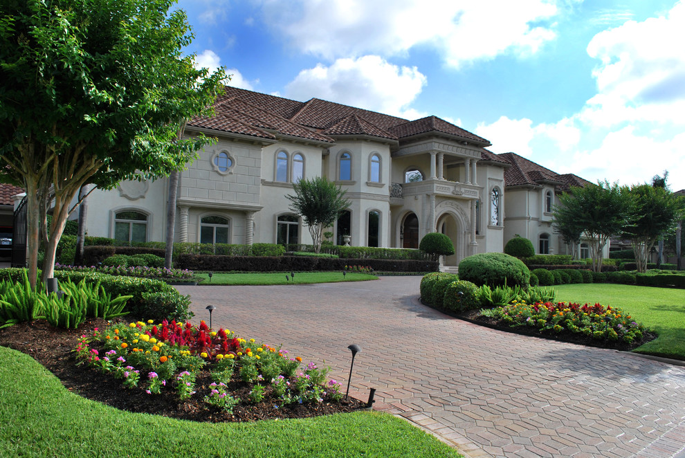 Inspiration for an expansive classic front driveway garden in Houston with a flowerbed.
