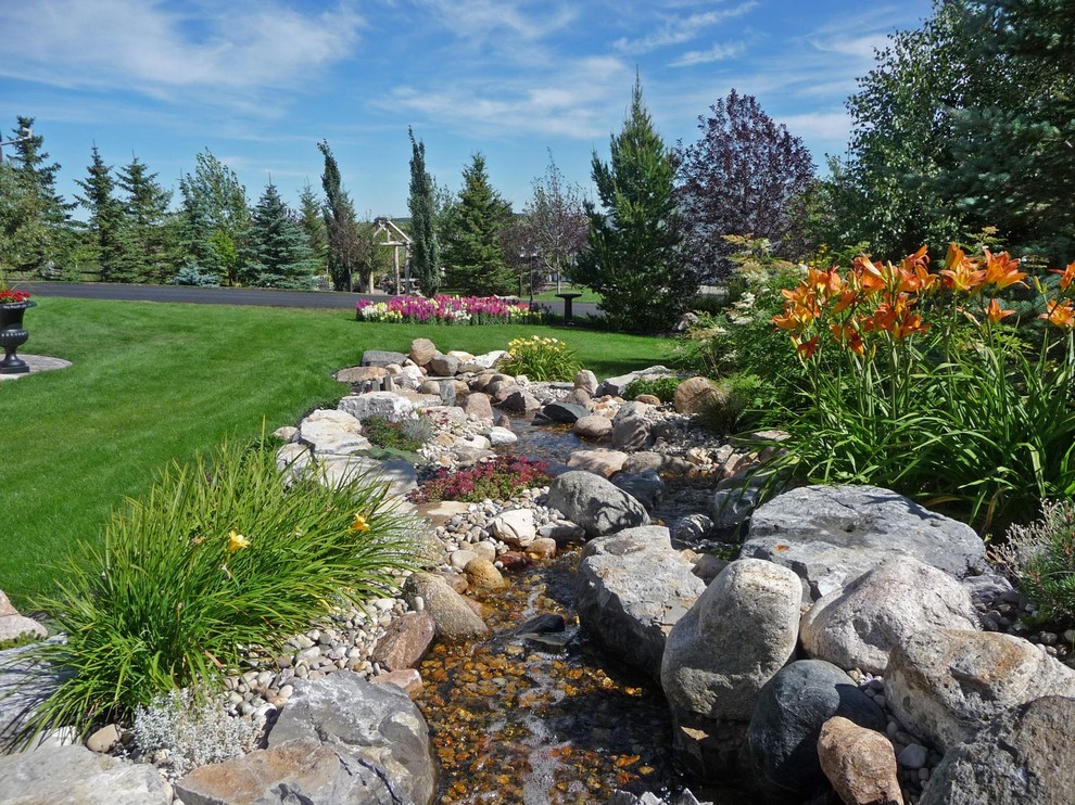 Geometrischer, Großer Klassischer Gartenteich hinter dem Haus, im Sommer mit direkter Sonneneinstrahlung und Natursteinplatten in Calgary