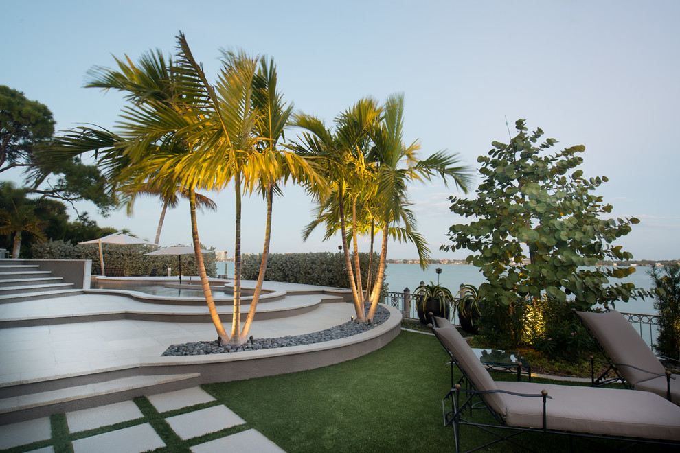 Moderner Garten hinter dem Haus mit Wasserspiel, direkter Sonneneinstrahlung und Betonboden in Tampa