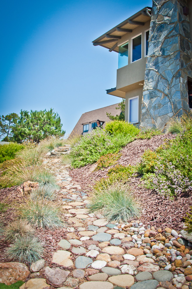 This is an example of a contemporary sloped full sun garden in San Luis Obispo with natural stone paving.