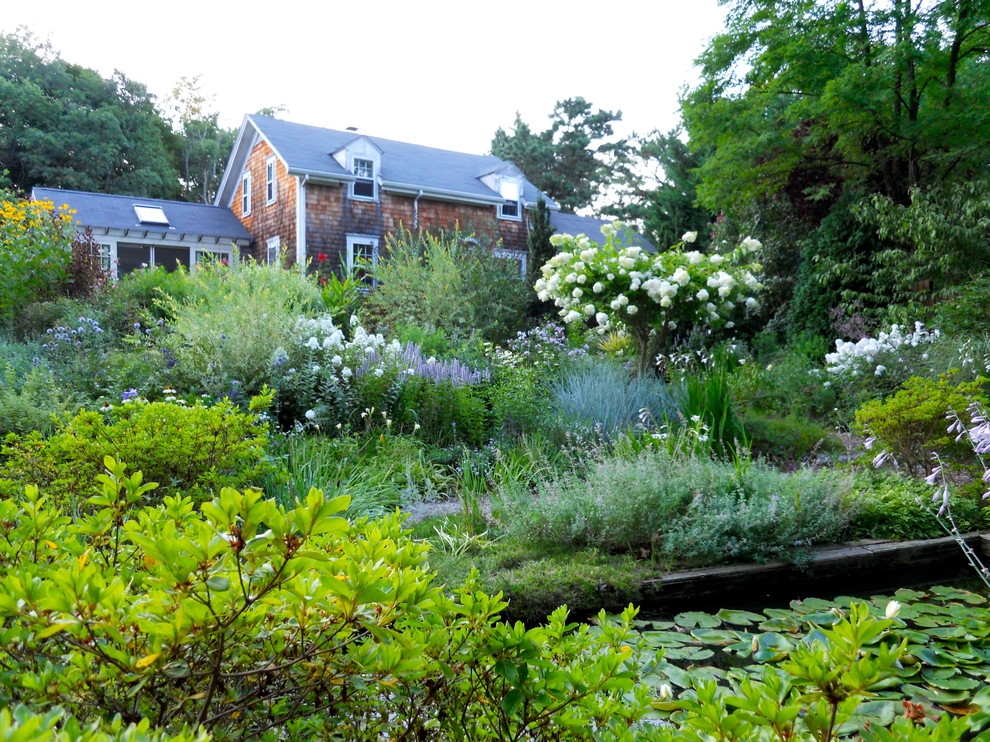 Foto de jardín clásico grande en patio trasero con jardín francés y estanque