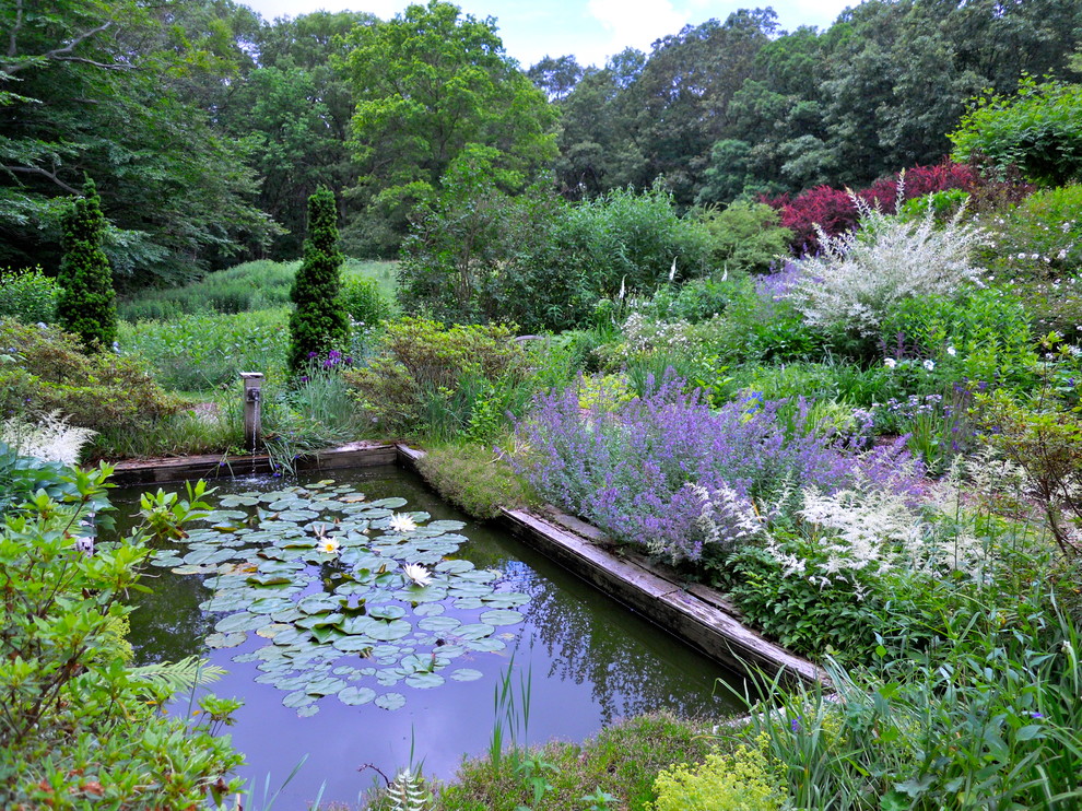 Diseño de jardín tradicional grande en patio trasero con jardín francés, exposición parcial al sol, mantillo y estanque