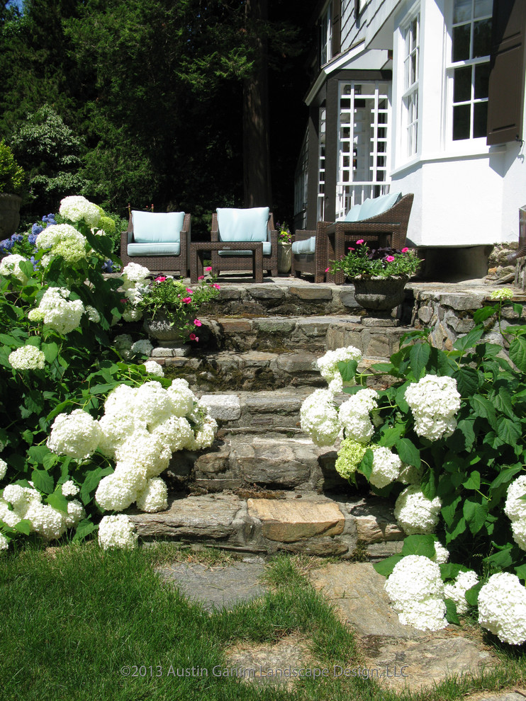 Halbschattiger Klassischer Garten im Sommer, hinter dem Haus mit Natursteinplatten in Bridgeport