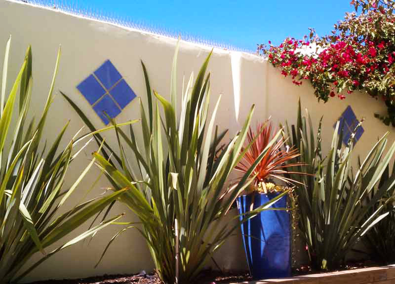Ejemplo de acceso privado mediterráneo de tamaño medio en verano en patio delantero con muro de contención, exposición total al sol y gravilla