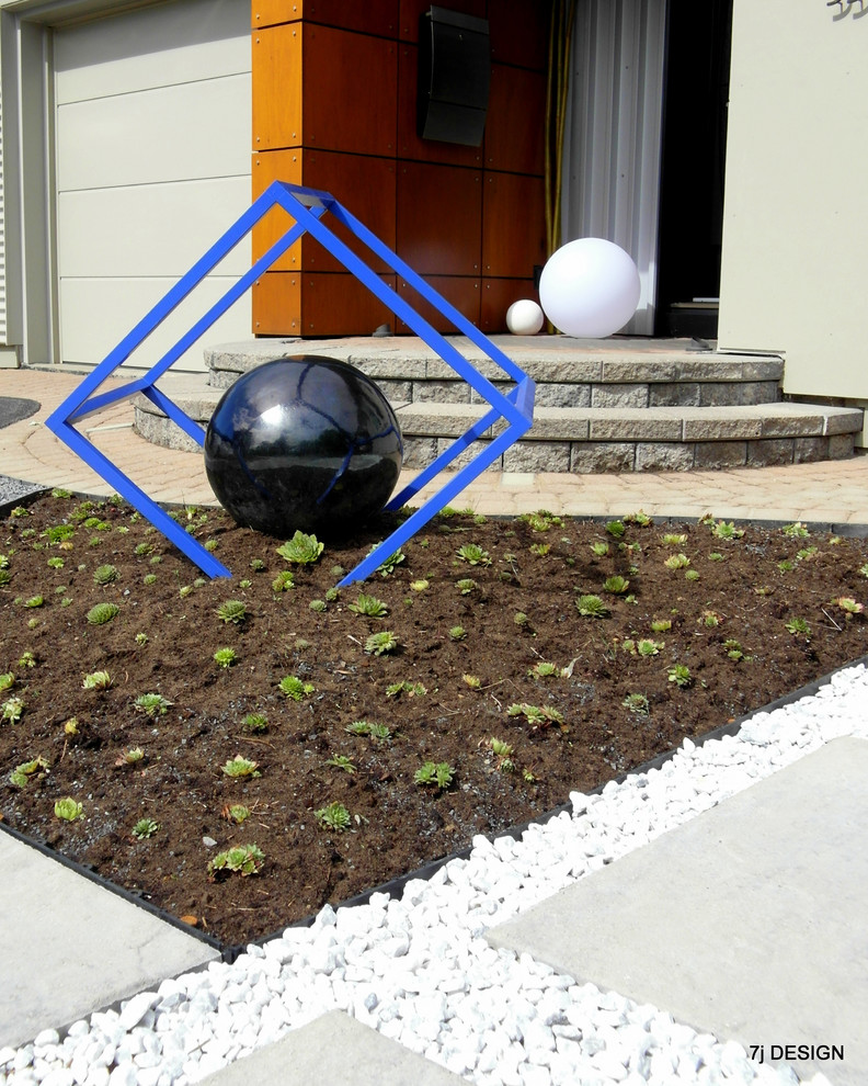 Пример оригинального дизайна: солнечный, летний участок и сад среднего размера на переднем дворе в стиле модернизм с растениями в контейнерах, хорошей освещенностью и мощением тротуарной плиткой
