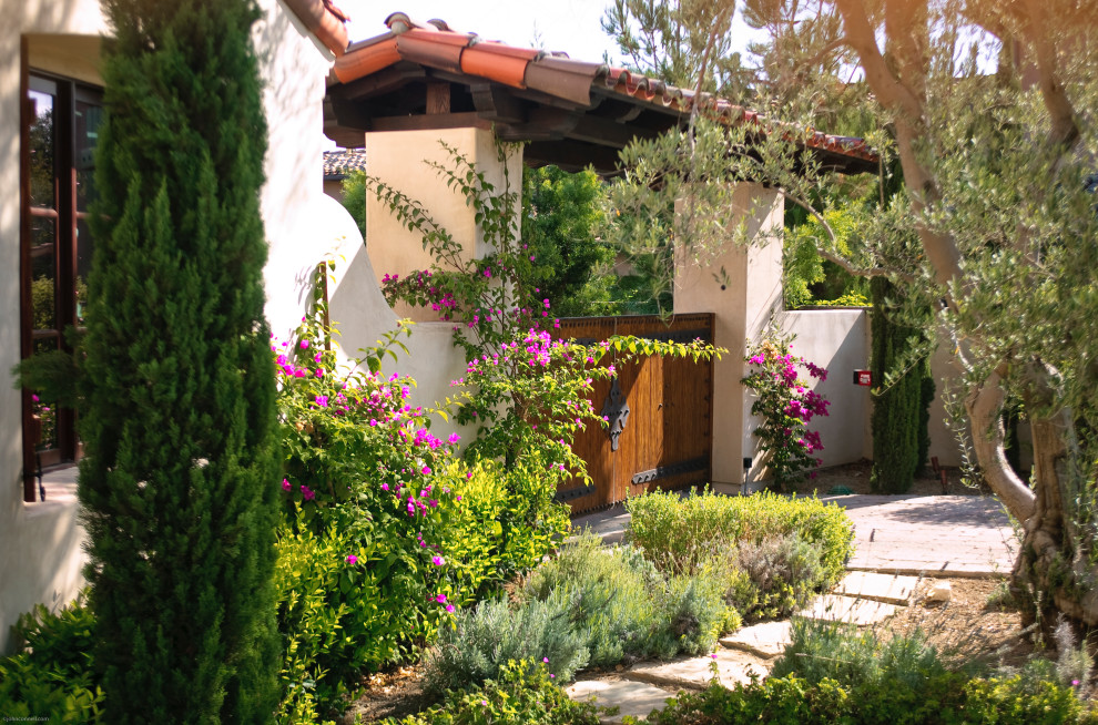 Modelo de acceso privado mediterráneo de tamaño medio en patio delantero con privacidad, exposición total al sol y adoquines de piedra natural